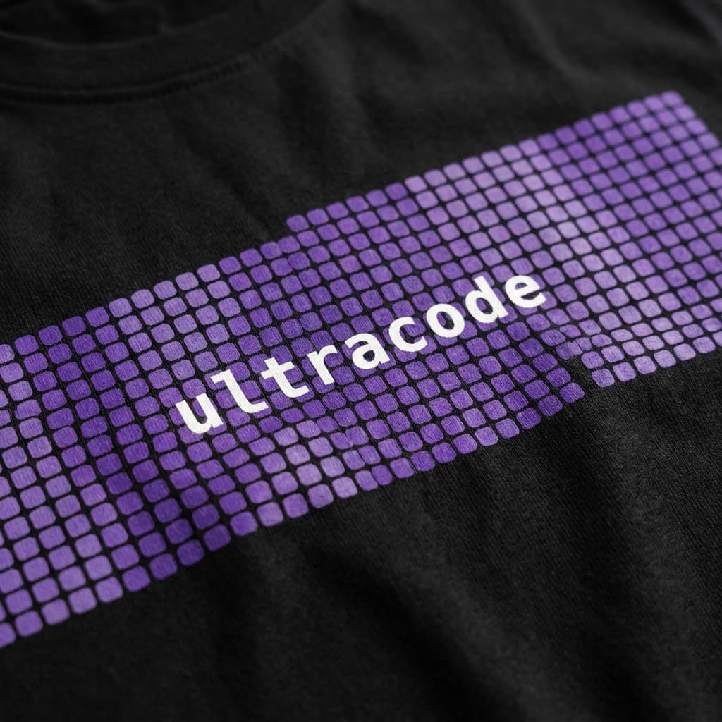 Close-up of the print: Black t-shirt printed with a purple pixel-grid panel reading ultracode